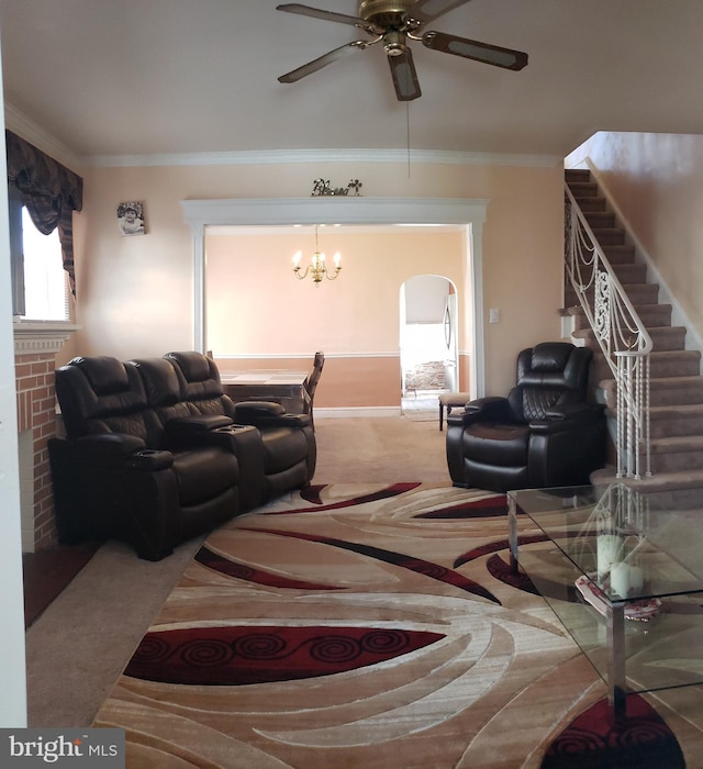 living room with ceiling fan with notable chandelier, crown molding, and carpet flooring