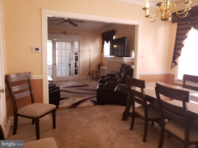 carpeted dining space with ceiling fan with notable chandelier and ornamental molding