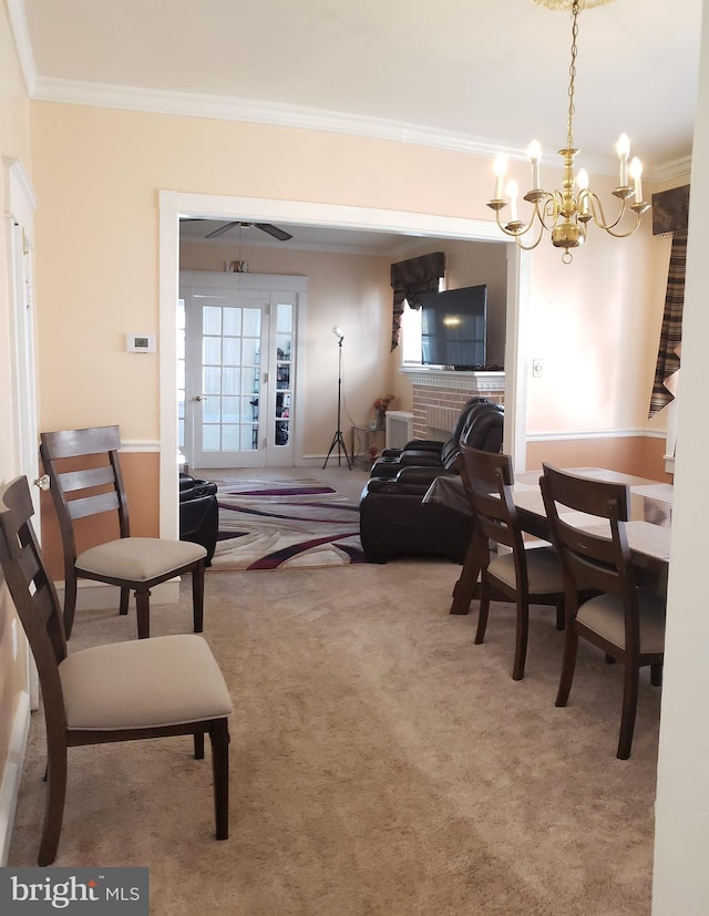 carpeted living room with ornamental molding, a brick fireplace, and an inviting chandelier