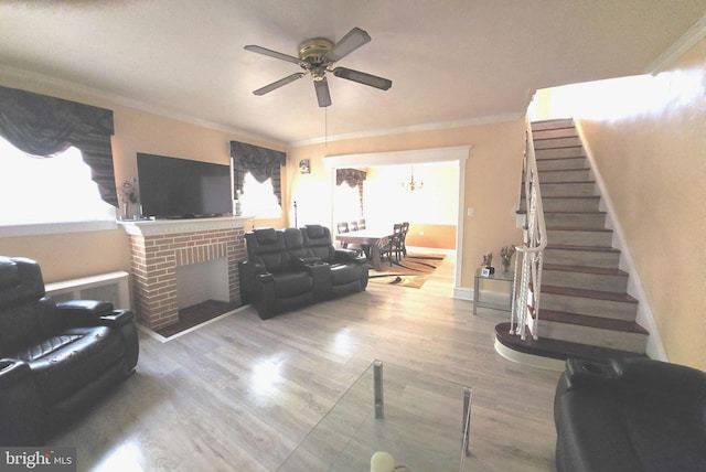 living room with a ceiling fan, crown molding, and a healthy amount of sunlight