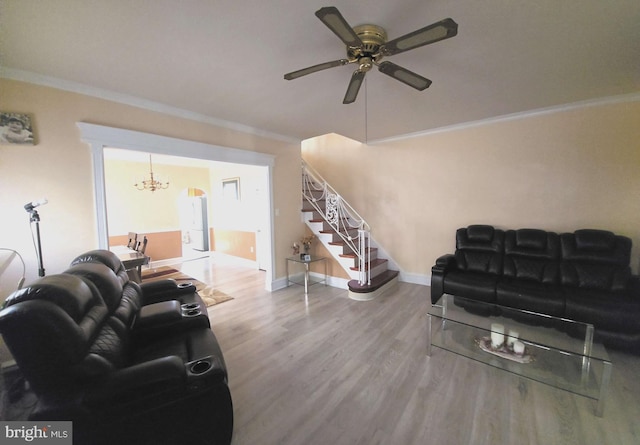 living room with stairs, ceiling fan with notable chandelier, crown molding, and wood finished floors