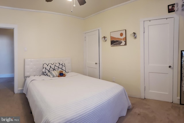 carpeted bedroom with ornamental molding and ceiling fan