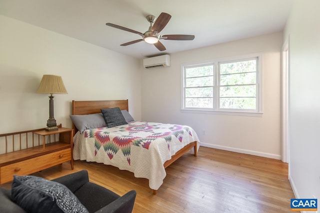 bedroom with ceiling fan, light hardwood / wood-style flooring, and a wall unit AC