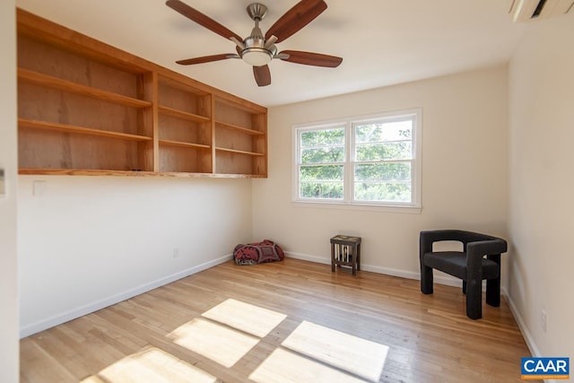 unfurnished room featuring ceiling fan, light wood-type flooring, and an AC wall unit