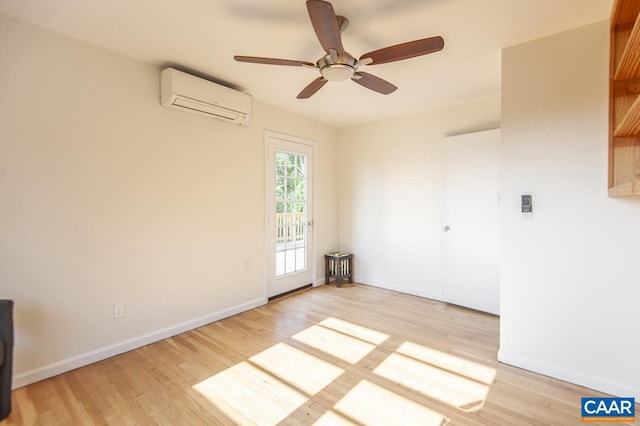 unfurnished room featuring a wall mounted AC, light hardwood / wood-style flooring, and ceiling fan