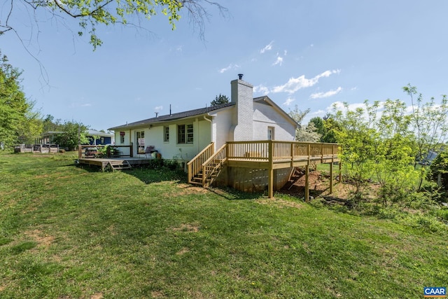 rear view of house featuring a yard and a deck