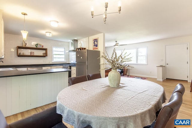 dining room featuring light hardwood / wood-style floors, sink, and ceiling fan