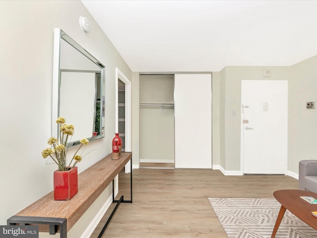 interior space with light wood finished floors, a closet, and baseboards