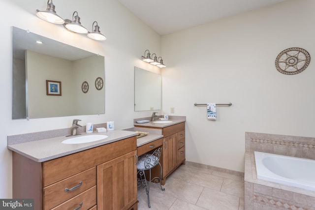 bathroom with vanity, a relaxing tiled tub, and tile patterned flooring