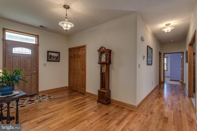 foyer entrance featuring light hardwood / wood-style flooring and a chandelier