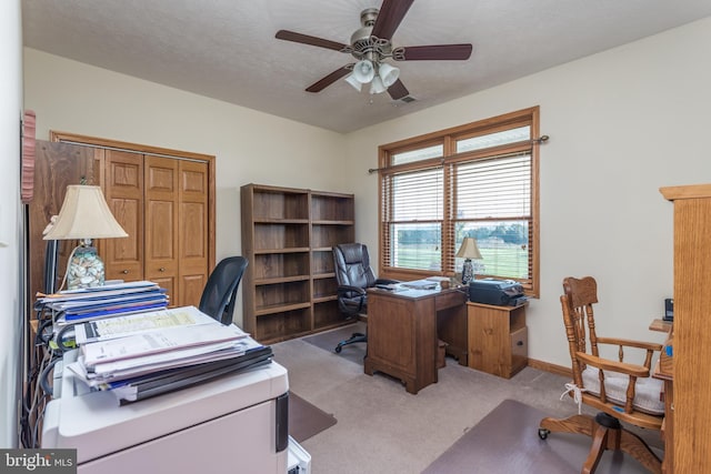 carpeted office featuring ceiling fan and a textured ceiling