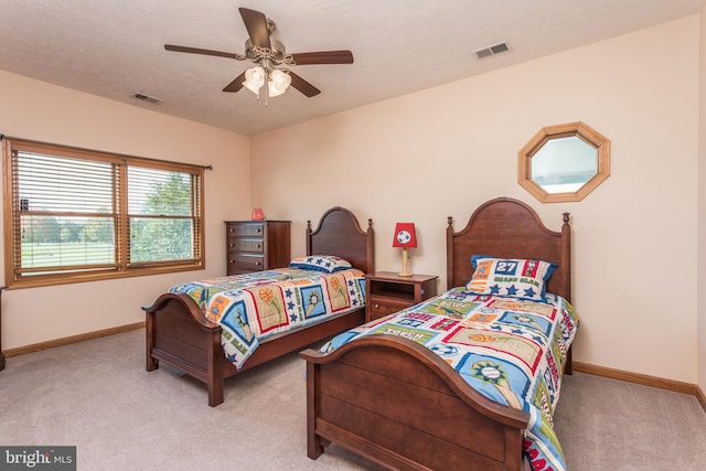 carpeted bedroom with a textured ceiling and ceiling fan