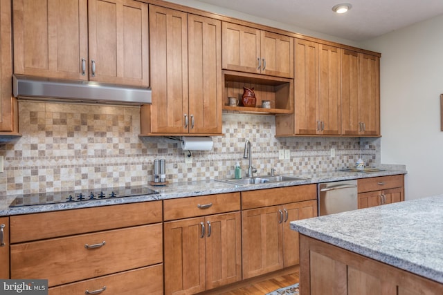 kitchen with sink, backsplash, black electric cooktop, hardwood / wood-style floors, and light stone counters