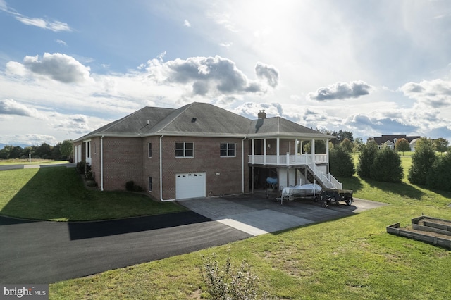 rear view of property featuring a lawn and a garage