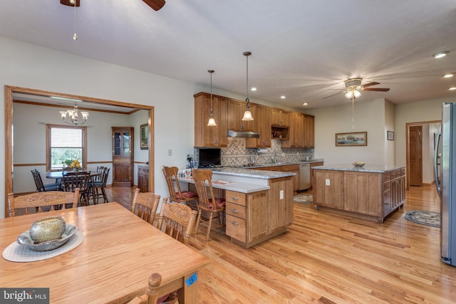 kitchen featuring decorative backsplash, decorative light fixtures, ceiling fan with notable chandelier, and light wood-type flooring