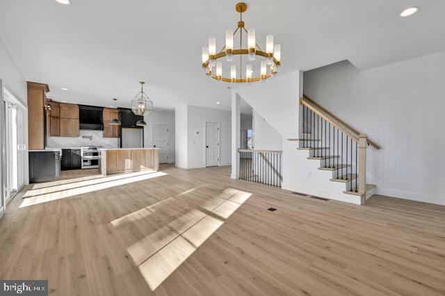 unfurnished living room featuring light hardwood / wood-style floors and a chandelier