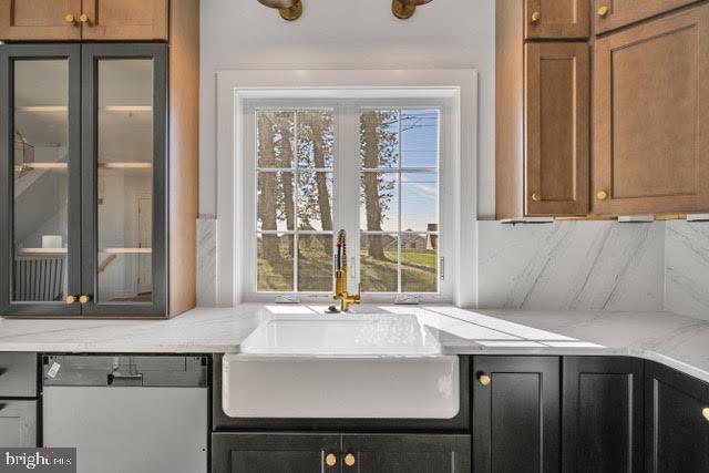 kitchen with dishwasher, sink, decorative backsplash, and a wealth of natural light