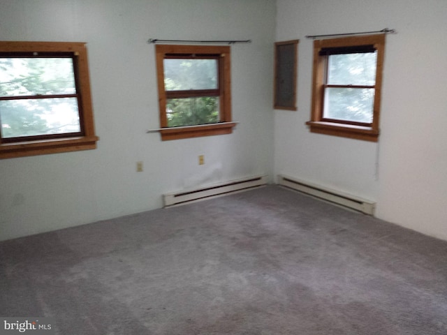 carpeted spare room featuring a baseboard radiator and plenty of natural light