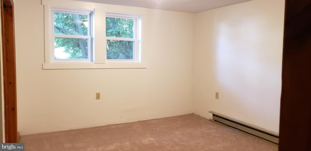 empty room featuring light colored carpet and baseboard heating