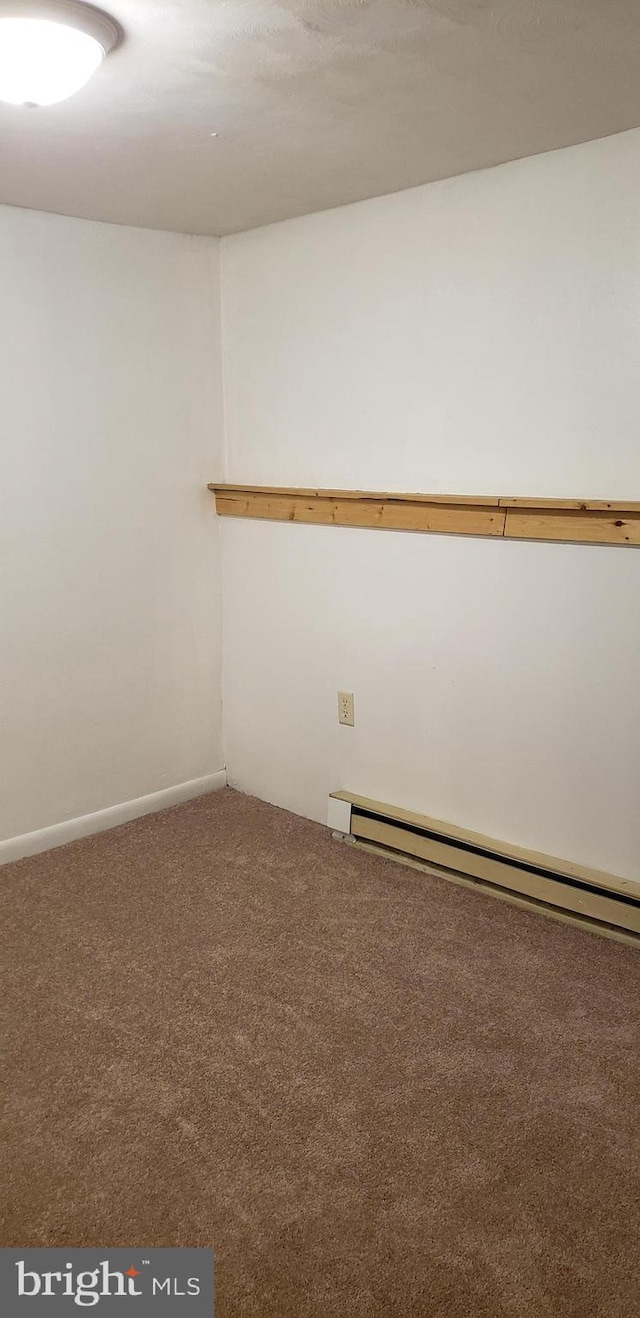 spare room featuring carpet and baseboard heating