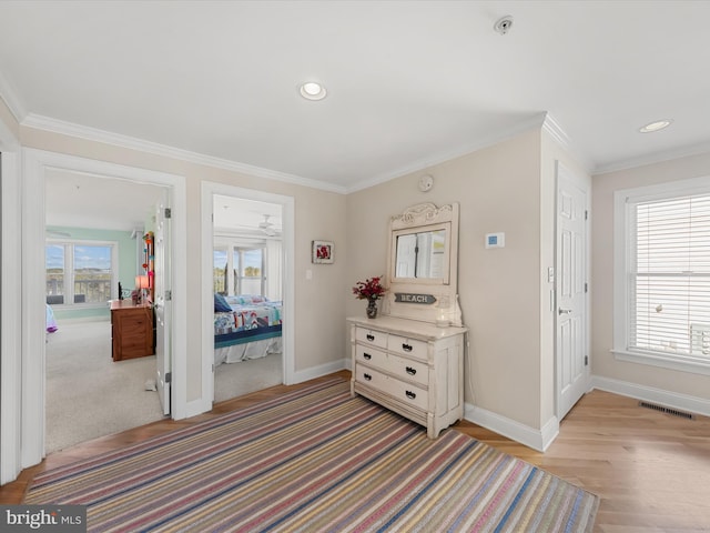 bedroom with crown molding, multiple windows, and light hardwood / wood-style floors