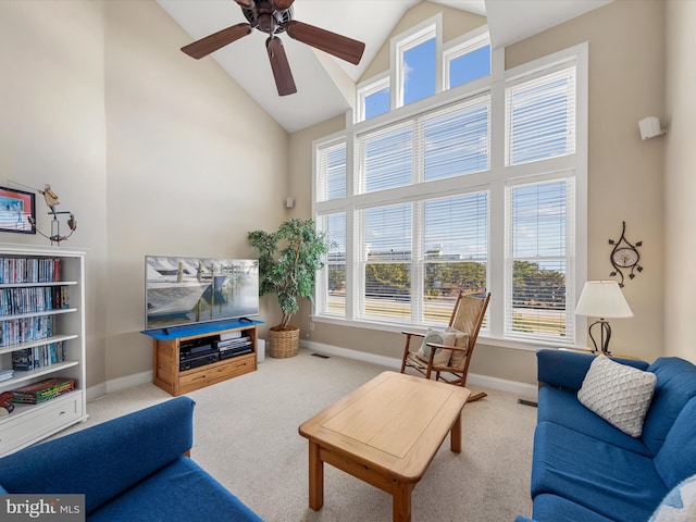 carpeted living room with ceiling fan, high vaulted ceiling, and plenty of natural light