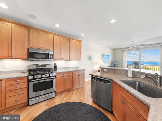 kitchen with light hardwood / wood-style flooring, stainless steel appliances, sink, and ceiling fan