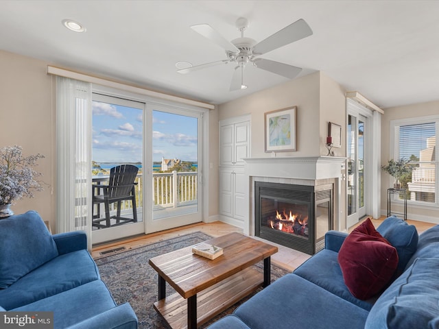 living room with light hardwood / wood-style floors, plenty of natural light, and ceiling fan