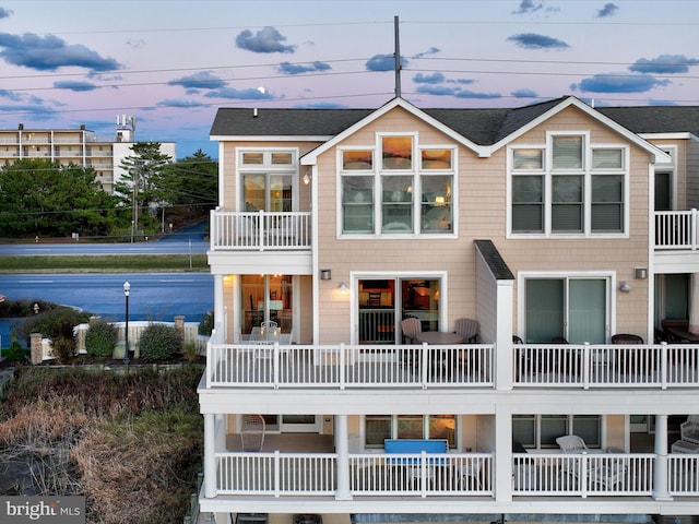 back house at dusk with a balcony