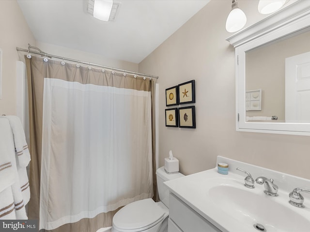 bathroom featuring vanity, a shower with shower curtain, and toilet