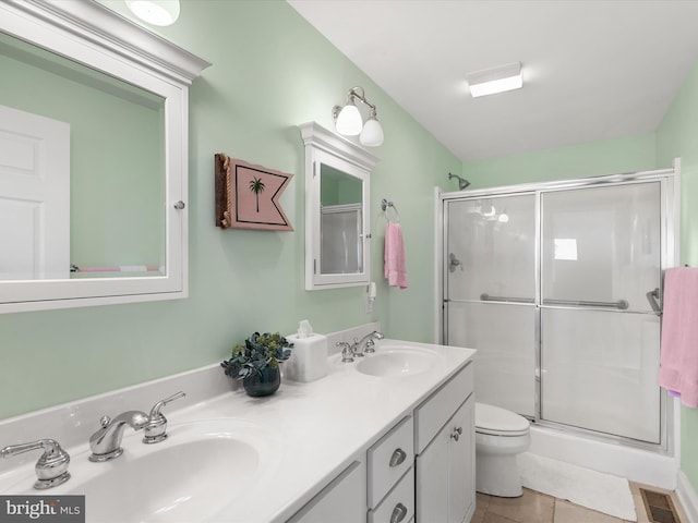 bathroom featuring toilet, an enclosed shower, vanity, and tile patterned flooring