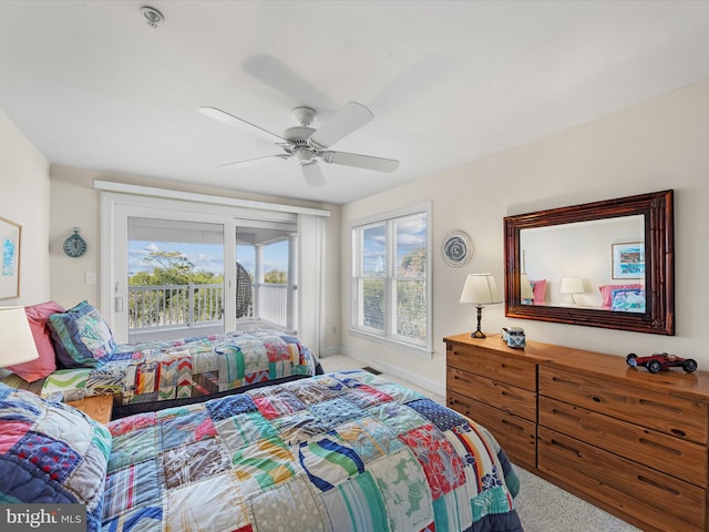 carpeted bedroom with ceiling fan, access to outside, and multiple windows