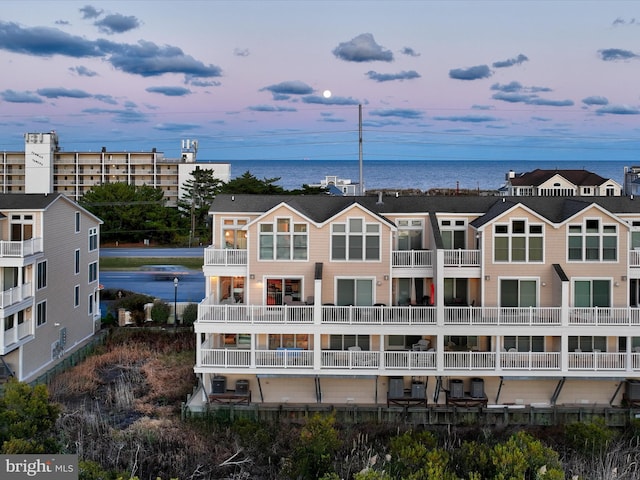 aerial view at dusk featuring a water view