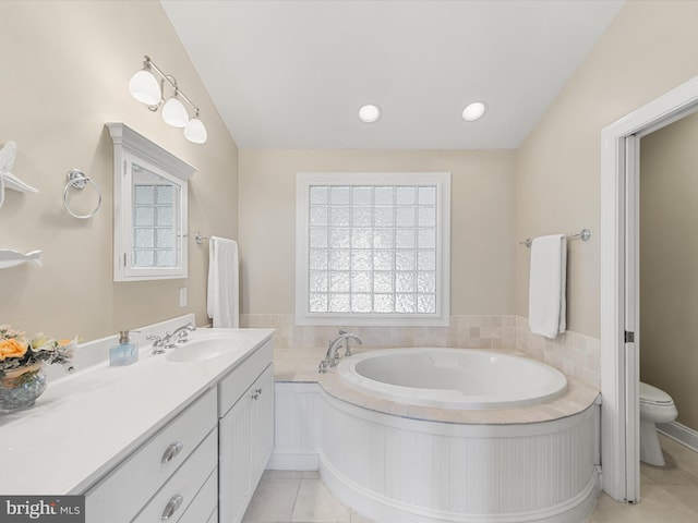 bathroom with a washtub, toilet, vaulted ceiling, vanity, and tile patterned flooring