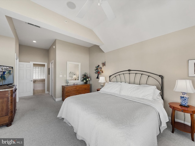 bedroom with ensuite bathroom, light colored carpet, vaulted ceiling, and ceiling fan