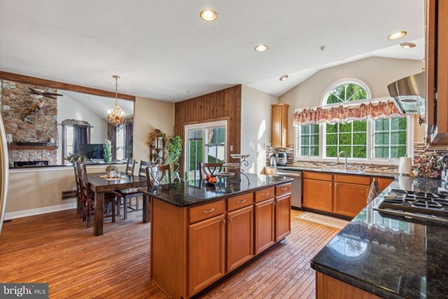 kitchen with dark stone counters, lofted ceiling, decorative light fixtures, and a kitchen island