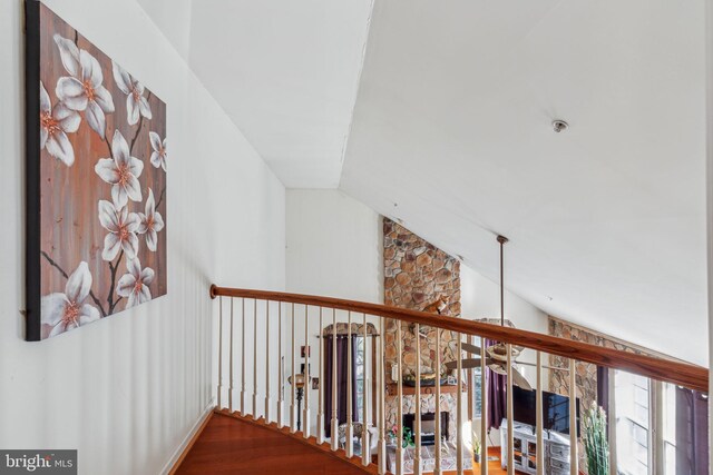 hall featuring hardwood / wood-style flooring and vaulted ceiling