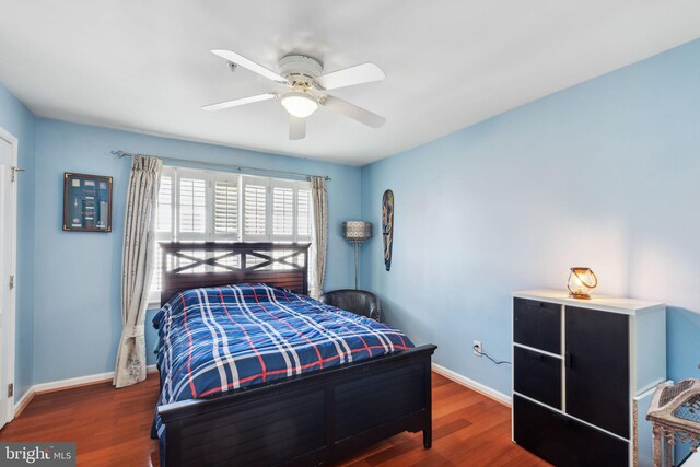 bedroom with dark hardwood / wood-style floors and ceiling fan