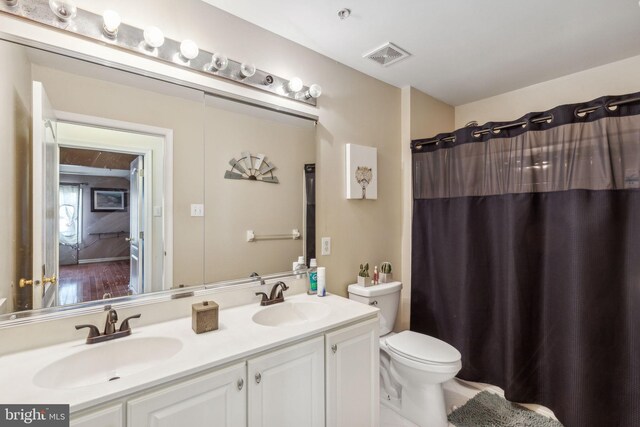 bathroom with toilet, a shower with curtain, and vanity