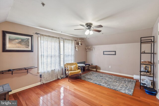 living area featuring lofted ceiling, hardwood / wood-style floors, and ceiling fan