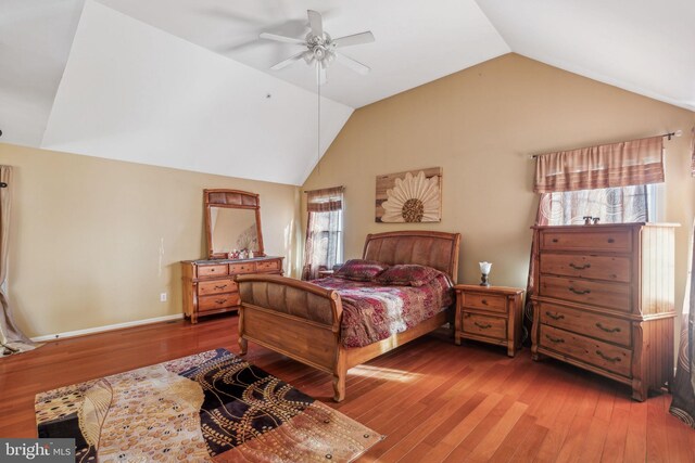 bedroom featuring multiple windows, hardwood / wood-style floors, lofted ceiling, and ceiling fan