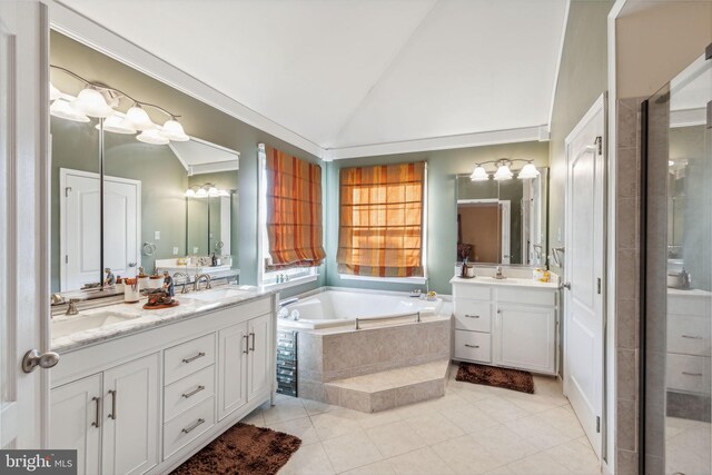 bathroom with vanity, a relaxing tiled tub, tile patterned floors, and vaulted ceiling