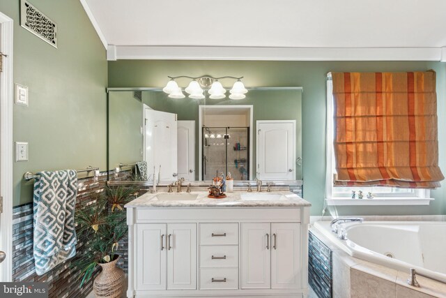 bathroom featuring vanity, ornamental molding, and independent shower and bath