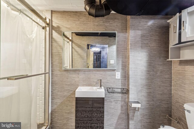 bathroom featuring vanity, toilet, tile walls, and curtained shower