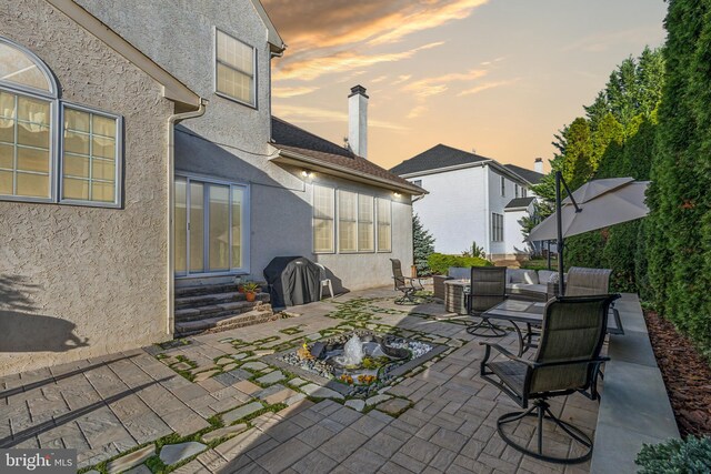 patio terrace at dusk with an outdoor hangout area and grilling area