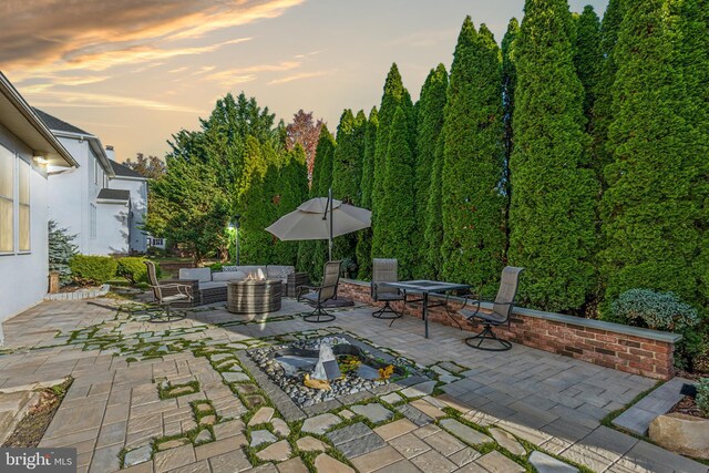 patio terrace at dusk featuring an outdoor hangout area