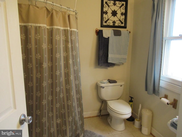 bathroom featuring tile patterned flooring, walk in shower, and toilet