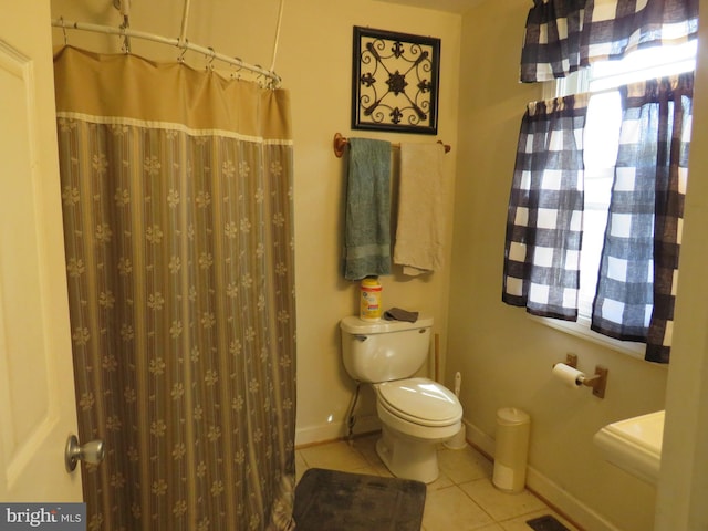 bathroom with a shower with curtain, plenty of natural light, toilet, and tile patterned floors