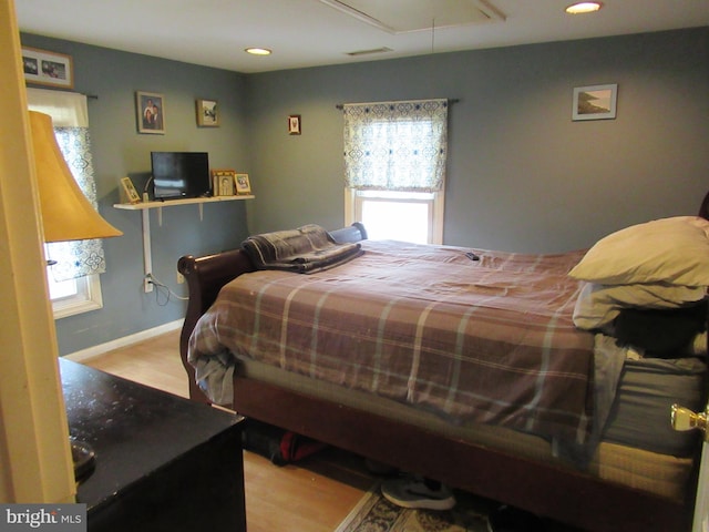 bedroom with light hardwood / wood-style floors and multiple windows