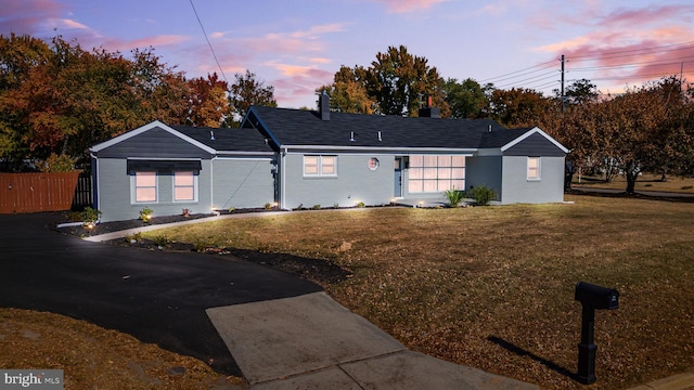 single story home with a lawn